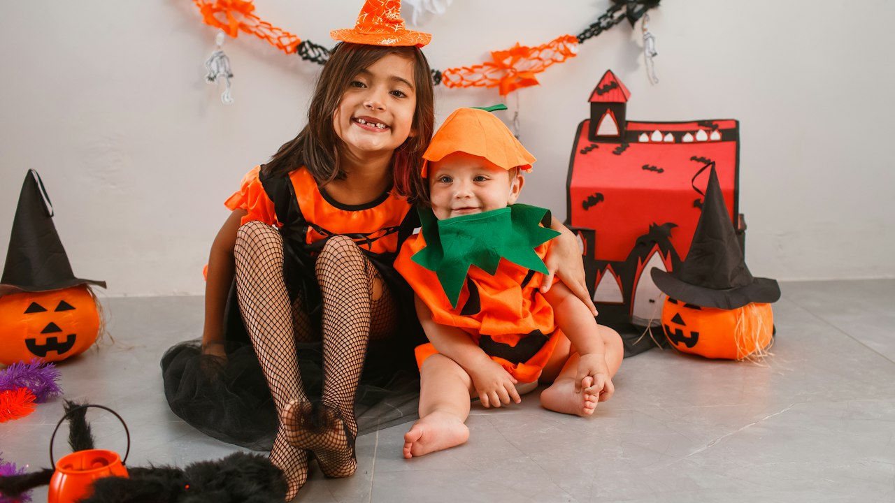 Kids and family dressed in Halloween costumes ready to play party games together