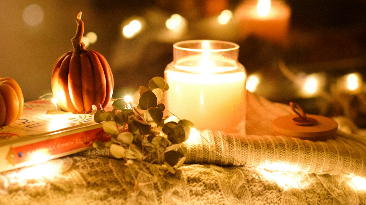 Cozy candlelit Halloween night at home with pumpkins, set up for a couple