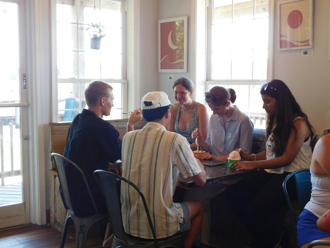 Group of friends sitting around a table playing party games indoors